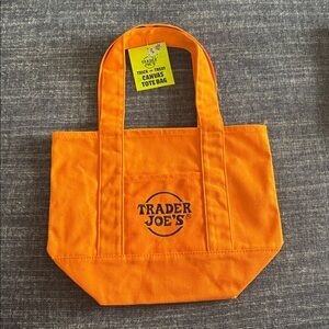 NWT Trader Joe’s Halloween Trick or Treat mini tote orange w/ black logo in hand
